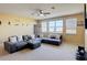 An upstairs living room features comfortable couches, a ceiling fan, and bright natural lighting through multiple windows at 14962 Fells Ln, Orlando, FL 32827