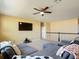 Comfortable living room with a large sectional sofa, ceiling fan, and flat-screen television at 14962 Fells Ln, Orlando, FL 32827