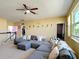 Spacious living room features a large sectional sofa, ceiling fan, and ample natural light, perfect for relaxation at 14962 Fells Ln, Orlando, FL 32827