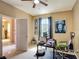 Bright home office with a window, a desk, and a view of an adjacent room at 14962 Fells Ln, Orlando, FL 32827