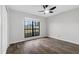 Bedroom featuring wood floors, ceiling fan, and a large window providing natural light at 157 Ambergate Ct, Debary, FL 32713