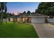 Picturesque single-story brick home at dusk, enhanced by a well-maintained lawn and cozy outdoor lighting at 157 Ambergate Ct, Debary, FL 32713