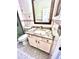 Bathroom with a granite countertop vanity, patterned floors, and a framed mirror at 16041 Lagoon Dr, Clermont, FL 34711