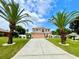 Beautiful two-story home with a well-manicured lawn and mature palm trees at 16041 Lagoon Dr, Clermont, FL 34711