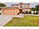 Charming two-story home with a manicured lawn and a two-car garage at 16041 Lagoon Dr, Clermont, FL 34711