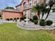 A two-story home with a well-manicured lawn and a water fountain at 16041 Lagoon Dr, Clermont, FL 34711