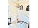 Elegant foyer with a grand chandelier, curved staircase, and arched windows, offering a bright and inviting entry at 16041 Lagoon Dr, Clermont, FL 34711