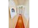 Inviting hallway featuring hardwood floors, arched doorways, and a glimpse of a window adding character at 16041 Lagoon Dr, Clermont, FL 34711