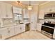 Well-lit kitchen boasts stainless steel appliances, white cabinetry, and a charming mosaic tile backsplash at 16041 Lagoon Dr, Clermont, FL 34711