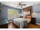 Inviting bedroom featuring a striking wood accent wall, window with shutters and hardwood floors at 219 Old Mill Cir, Kissimmee, FL 34746