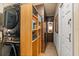 Well-organized laundry room featuring a stacked washer/dryer and built-in wooden storage shelves for added convenience at 219 Old Mill Cir, Kissimmee, FL 34746