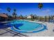 Large community swimming pool with tiled sundeck, palm trees, and wrought iron fence overlooking a pond at 2208 Antigua Pl # 932, Kissimmee, FL 34741