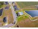 Aerial view of a community featuring a pool, playground, and pond, near houses and a cultivated agricultural field at 2226 Majestic Span Ave, Eagle Lake, FL 33839