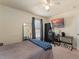 Well-lit bedroom featuring a ceiling fan, plush carpet, and large television on the wall at 225 Indiana St, Leesburg, FL 34748