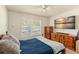 Bedroom featuring natural light, dark blue bedding, and a large flat screen tv at 225 Indiana St, Leesburg, FL 34748