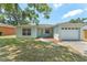 Charming single-story home with attached garage and inviting front entrance with chairs at 225 Indiana St, Leesburg, FL 34748