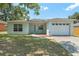Charming single-story home featuring a well-manicured lawn and an attached one car garage at 225 Indiana St, Leesburg, FL 34748
