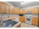 Functional kitchen with wood cabinets, essential appliances, and a practical layout at 225 Indiana St, Leesburg, FL 34748