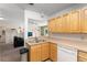 Well-lit kitchen features wood cabinetry, stainless steel sink and white appliances at 225 Indiana St, Leesburg, FL 34748