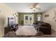 Comfortable living room with neutral carpet and a ceiling fan, with access to the backyard at 225 Indiana St, Leesburg, FL 34748