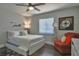 Comfortable bedroom features a cozy queen bed, ceiling fan and a stylish accent chair by the window at 2714 Hunt Club Ln, Orlando, FL 32826