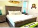 Bedroom with a wooden bed frame, two wooden nightstands, and tropical-themed decor at 3013 Latitude Ln, Kissimmee, FL 34747