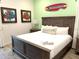 Bedroom featuring a wooden bed frame, decorative wall art, and light-colored walls at 3013 Latitude Ln, Kissimmee, FL 34747