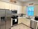 Modern kitchen with stainless steel appliances, white countertops, and wooden floors at 3013 Latitude Ln, Kissimmee, FL 34747