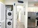 Convenient laundry area with stacked washer and dryer, and a hallway leading to other rooms at 3013 Latitude Ln, Kissimmee, FL 34747