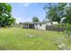 Fenced backyard featuring a large lawn, playset, trees, and a screened patio at 3520 Balsam Dr, Winter Park, FL 32792