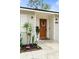 Charming front entrance features a wooden door, stylish accents, and manicured landscaping at 3520 Balsam Dr, Winter Park, FL 32792