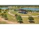 Community park featuring an outdoor stage, walking paths, lush trees, and a serene lake at 3697 Rolling Hills Ln, Apopka, FL 32712