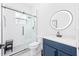 Updated bathroom featuring a glass shower, sleek fixtures, and a stylish vanity with a circular mirror at 3697 Rolling Hills Ln, Apopka, FL 32712