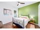 Bright bedroom featuring a large window, an accent wall, and minimalist decor at 3697 Rolling Hills Ln, Apopka, FL 32712
