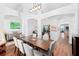 Bright dining room with hardwood flooring, featuring modern lighting, with views into other living spaces at 3697 Rolling Hills Ln, Apopka, FL 32712