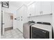 Well-appointed laundry room with modern appliances, stylish flooring, and ample storage cabinets at 3697 Rolling Hills Ln, Apopka, FL 32712