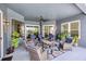 Relaxing covered patio area with comfortable seating, ceiling fan, and views of the beautifully landscaped backyard at 3697 Rolling Hills Ln, Apopka, FL 32712