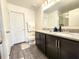 Bathroom featuring a double sink vanity with granite counters, and a large mirror at 3838 Whitetail Ct, St Cloud, FL 34772