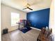 Bedroom with sleek ceiling fan, blue accent wall, and wood-style laminate flooring at 3838 Whitetail Ct, St Cloud, FL 34772