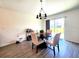 A dining room featuring a round table with seating for four, a modern chandelier and a sliding glass door at 3838 Whitetail Ct, St Cloud, FL 34772
