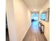 Hallway showcasing wood-look flooring and access to the living room with natural light at 3838 Whitetail Ct, St Cloud, FL 34772