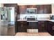 Modern kitchen featuring stainless steel appliances, dark cabinetry, and stylish granite countertops at 3838 Whitetail Ct, St Cloud, FL 34772