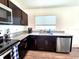 Modern kitchen featuring stainless steel appliances, dark cabinetry, and stylish granite countertops at 3838 Whitetail Ct, St Cloud, FL 34772