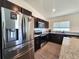 Modern kitchen featuring stainless steel appliances, dark cabinetry, and stylish granite countertops at 3838 Whitetail Ct, St Cloud, FL 34772