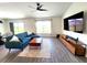 Living room features a modern sofa, a ceiling fan, contemporary furniture, a large window and modern flooring at 3838 Whitetail Ct, St Cloud, FL 34772