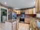 Updated kitchen featuring stainless steel appliances, granite countertops, a kitchen island, and access to the laundry room at 408 Becky St, Orlando, FL 32824