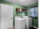 Laundry room features full size washer and dryer and storage shelves above at 408 Becky St, Orlando, FL 32824