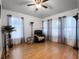 Bright living room features wood floors, ceiling fan and large windows with decorative curtains at 408 Becky St, Orlando, FL 32824