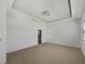 Spacious bedroom with tray ceiling and a view into the ensuite bathroom at 4116 Se 9Th Ave, Ocala, FL 34480
