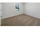 Empty bedroom with fresh paint, carpet, and a large window letting in light at 4116 Se 9Th Ave, Ocala, FL 34480